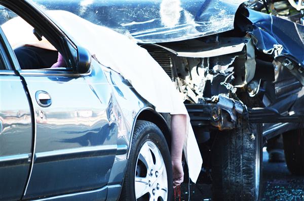 A white sheet covers the "deceased" victim of Henderson's Mock Crash 